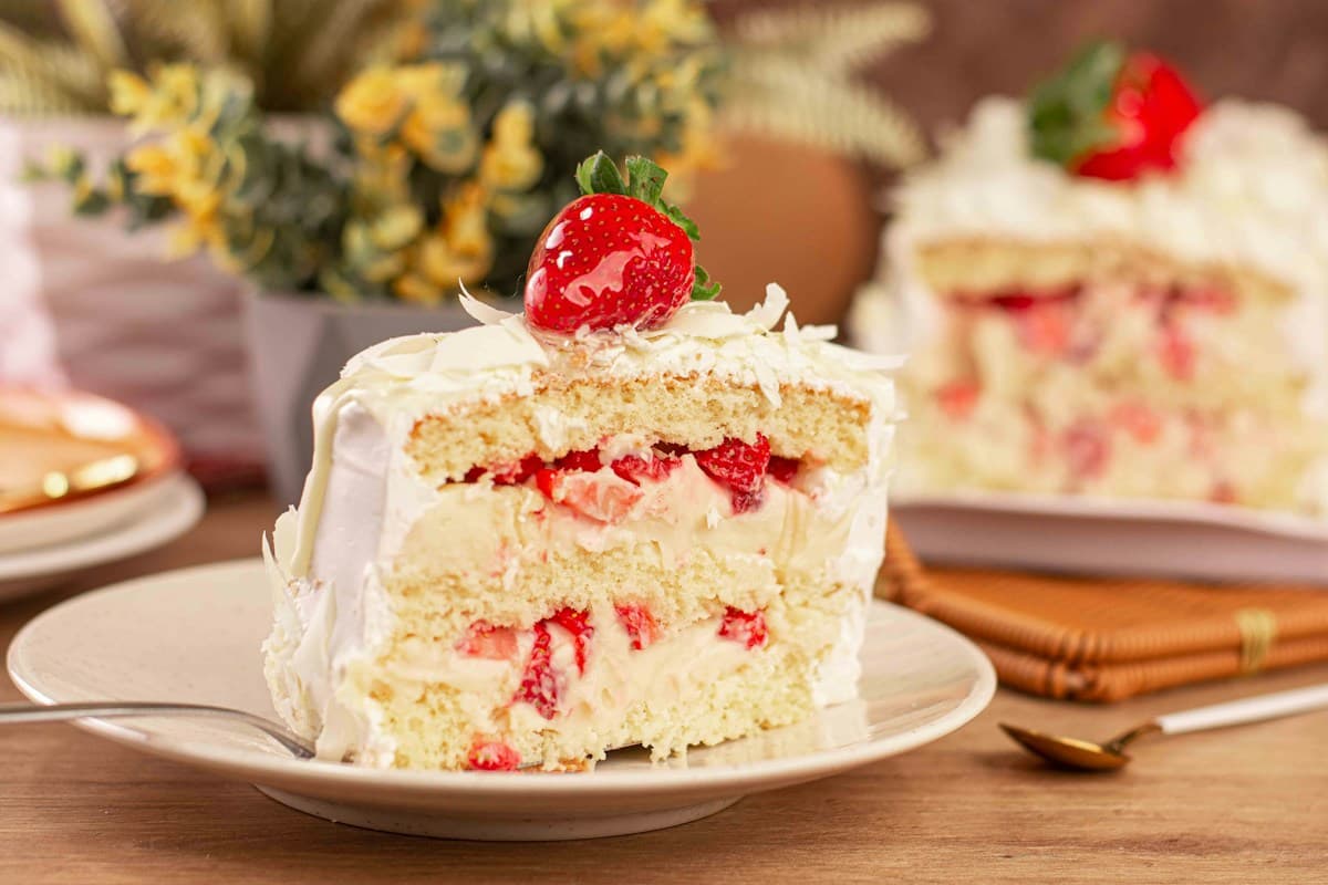 Un trozo de torta de frutilla con crema