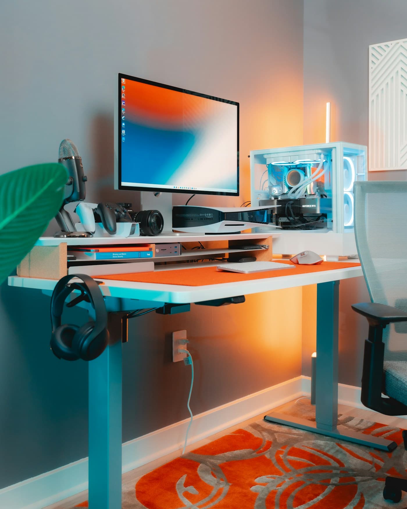 Escritorio con monitor, teclado y audífonos colgados del borde
